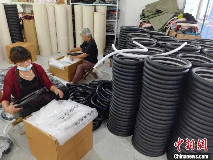 圖為村民在汽車飾品企業(yè)生產(chǎn)車間中工作?！巫雍?攝