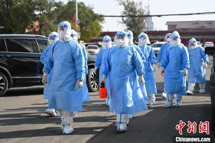 圖為醫(yī)務(wù)人員在封閉小區(qū)做防控工作?！⑽娜A 攝
