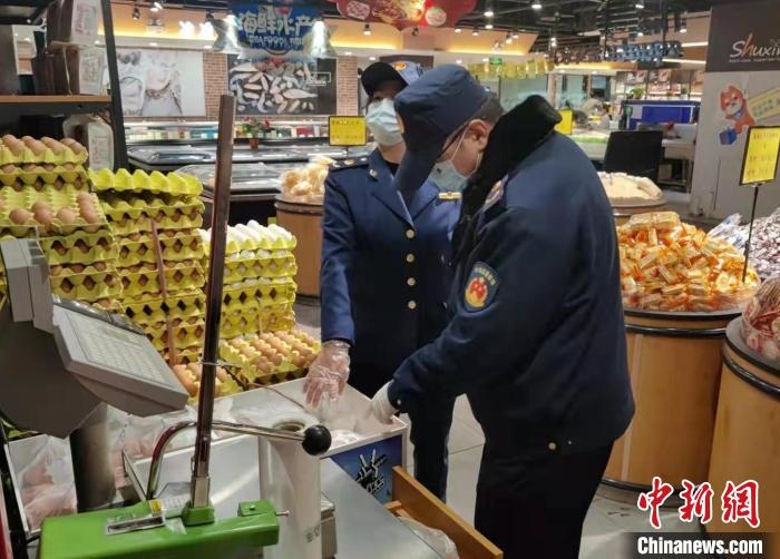 圖為疫情期間，甘肅嘉峪關(guān)市場(chǎng)監(jiān)管局工作人員檢查蔬菜市場(chǎng)?！?柴佳楠 　攝