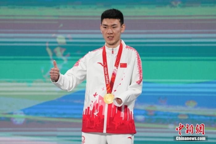 3月6日，梁景怡在延慶頒獎(jiǎng)廣場(chǎng)領(lǐng)獎(jiǎng)臺(tái)上豎起大拇指。當(dāng)日，在國(guó)家高山滑雪中心舉行的北京2022年冬殘奧會(huì)殘奧高山滑雪男子超級(jí)大回轉(zhuǎn)—站姿決賽中，中國(guó)選手梁景怡奪得冠軍。 <a target='_blank' href='/'>中新社</a>記者 楊華峰 攝