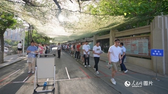 6月7日，烏魯木齊市第七十中學(xué)門口，考生們有序進入考場。人民網(wǎng) 李欣洋攝