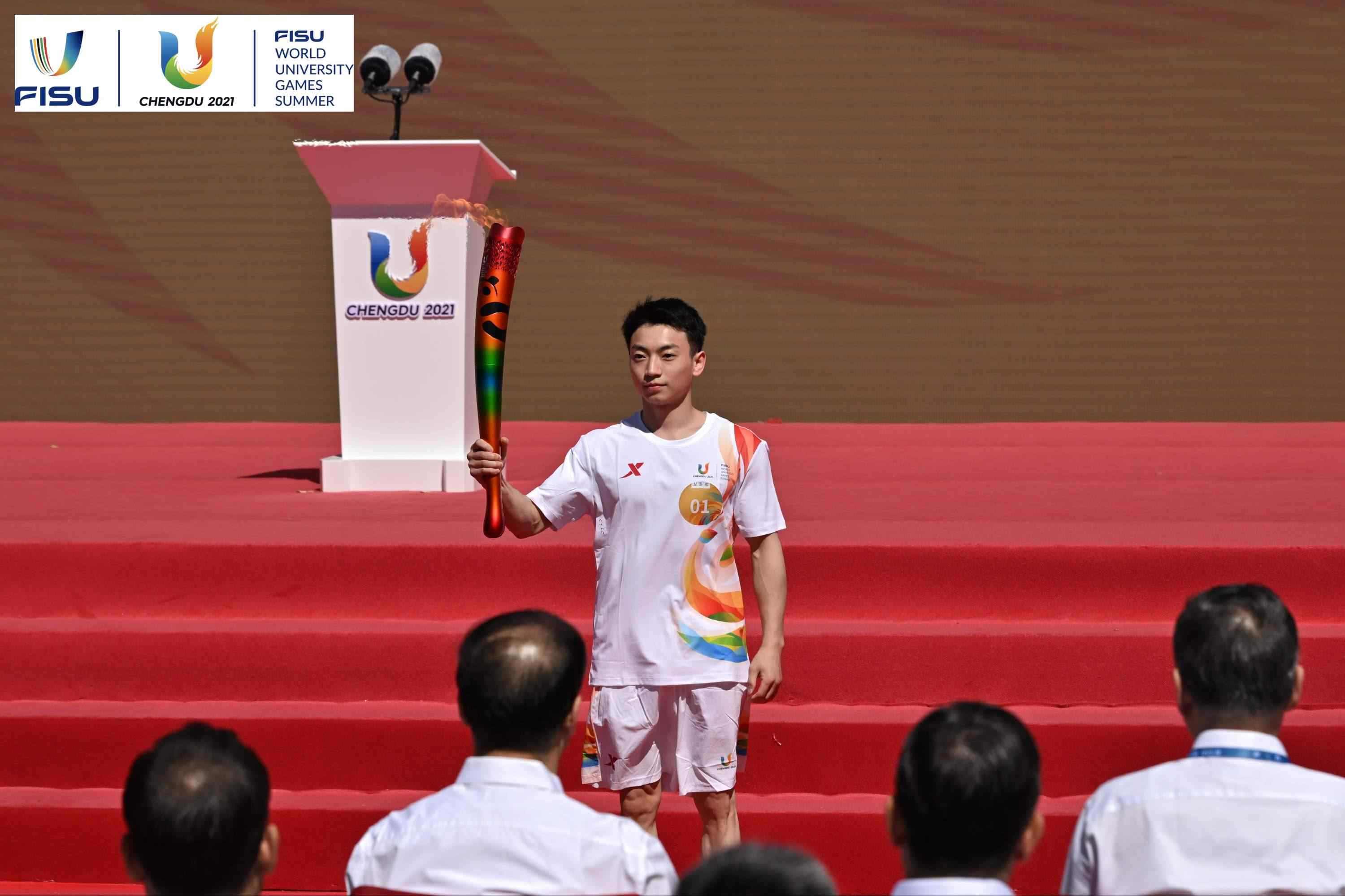 成都大運會火炬手、奧運冠軍鄒敬園高舉火炬。 圖片來源：成都大運會執(zhí)委會供圖