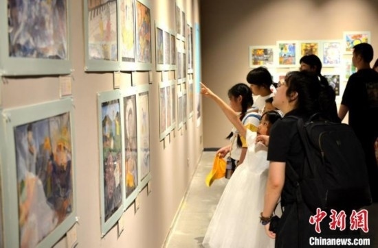 圖為家長(zhǎng)帶著孩子參觀展覽。呂明 攝