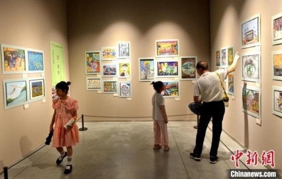 圖為家長(zhǎng)帶著孩子參觀展覽。呂明 攝