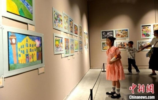 圖為家長(zhǎng)帶著孩子參觀展覽。呂明 攝