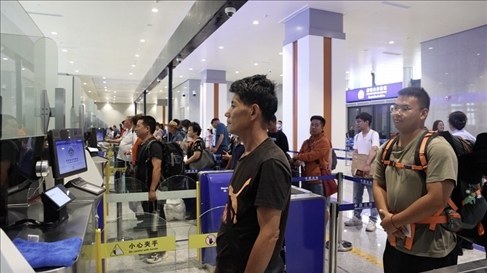 6月13日，乘坐中老鐵路國際旅客列車的旅客在磨憨邊檢大廳排隊候檢。李揚 攝