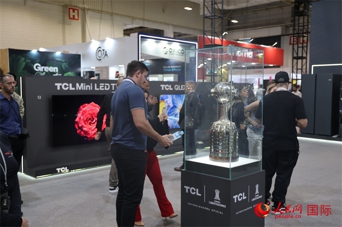 參觀者在TCL展臺前觀看南美解放者杯獎杯，據(jù)介紹，TCL是南美解放者杯（2023—2026賽季）全球官方合作伙伴。（人民網(wǎng)記者 時元皓攝）