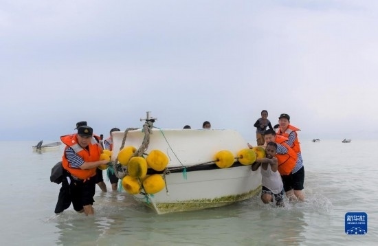 7月21日，中國海軍“和平方舟”號醫(yī)院船醫(yī)護人員涉水登島，前往基里巴斯一診療點。新華社記者 黎云 攝