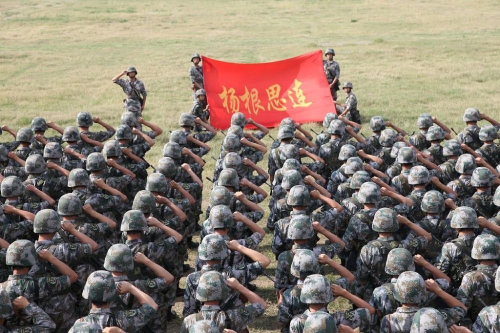 ↑“楊根思連”官兵執(zhí)行任務(wù)前向連旗宣誓（資料照片）。新華社發(fā)