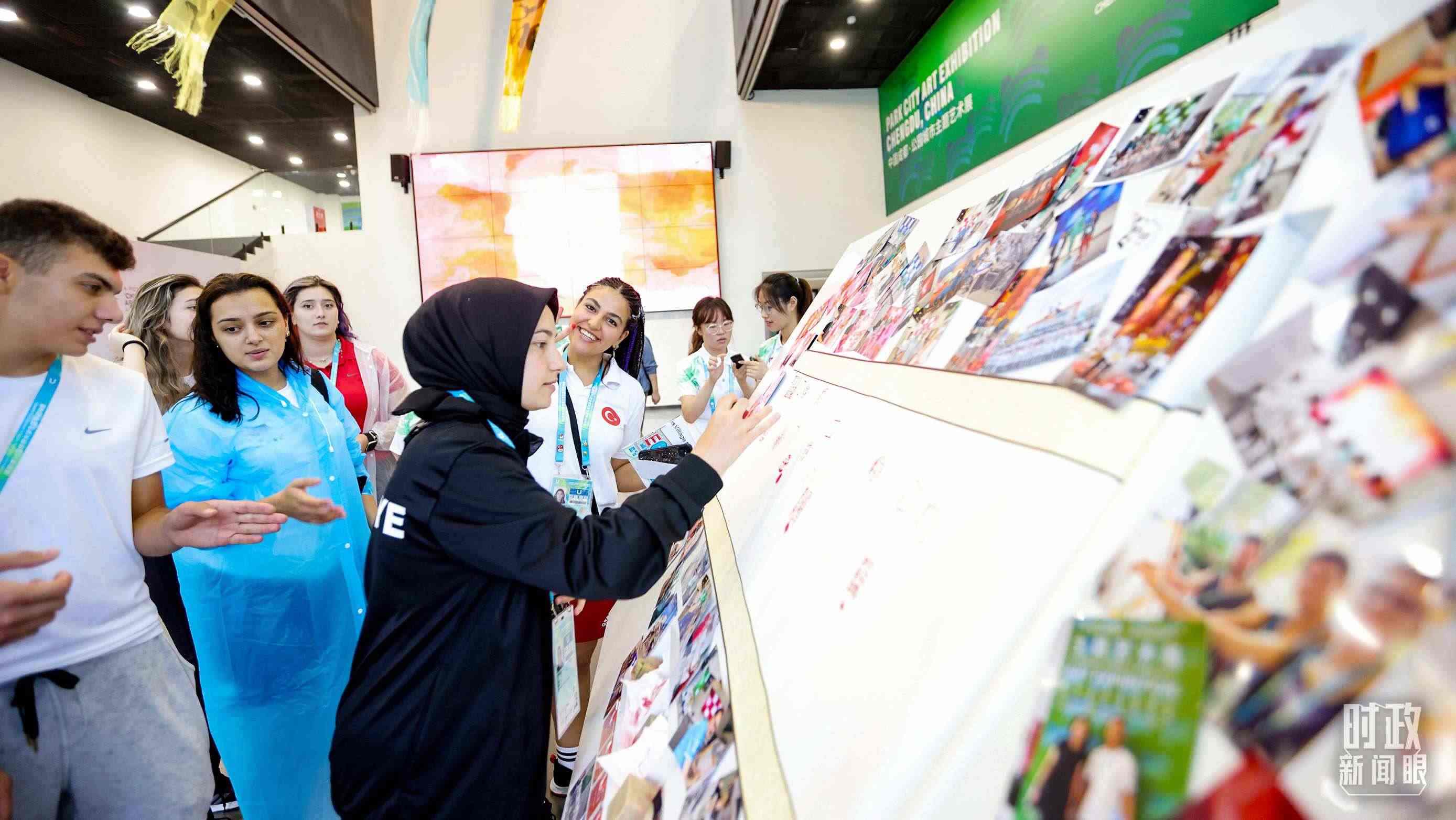 各國青年運動員正在參觀成都大運村內(nèi)的“雪山下的公園城市，煙火里的幸福成都”主題藝術展。（總臺央視記者魏幫軍拍攝）
