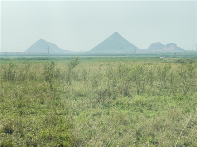遠處礦方存放的矸石堆成山(中國之聲記者江曉晨 攝)