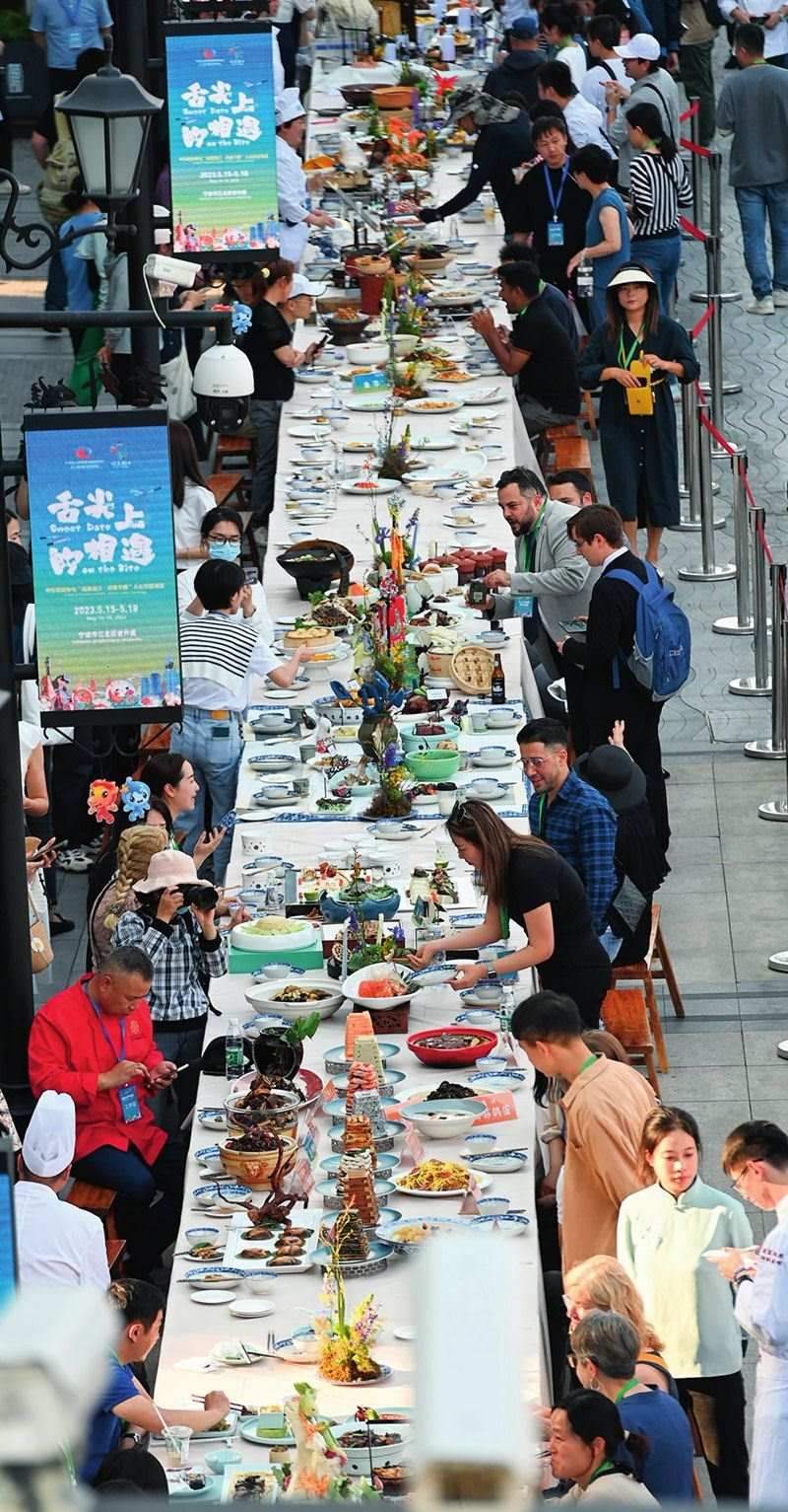 市民和游客在寧波舉辦的第三屆中國—中東歐國家博覽會暨國際消費(fèi)品博覽會上品嘗融合中國和中東歐美食的長桌宴（2023年5月15日攝）。黃宗治攝/本刊