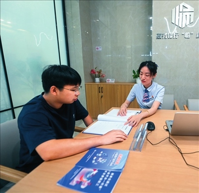 在杭州市臨安區(qū)政務(wù)服務(wù)中心的“為企服務(wù)中心”，黨員志愿者（右）解答企業(yè)主的疑問（2023年7月7日攝）。徐昱攝/本刊