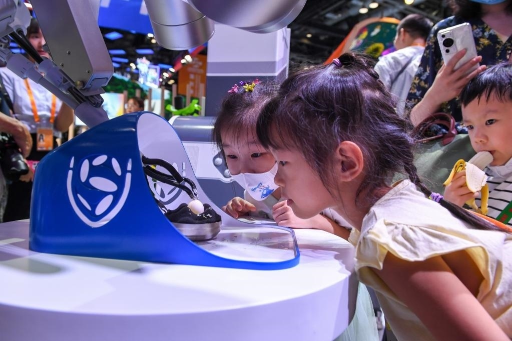 9月3日，幾名小朋友在國家會議中心觀看單孔腔鏡手術機器人展示。新華社記者 鞠煥宗 攝