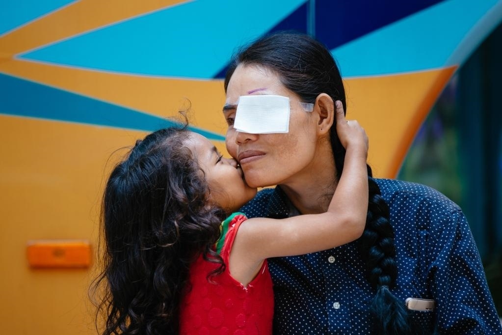 2019年3月15日，在柬埔寨磅湛省醫(yī)院，即將接受白內(nèi)障手術(shù)的患者孫美樂接受女兒的親吻祝福。在接受了中國醫(yī)療隊的白內(nèi)障義診手術(shù)后，她的視力逐步恢復(fù)，生活有了新的光明和希望。