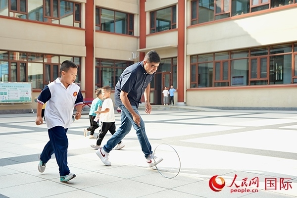 來自巴基斯坦的沙杰在滾鐵環(huán)。人民網(wǎng) 盧鵬宇攝