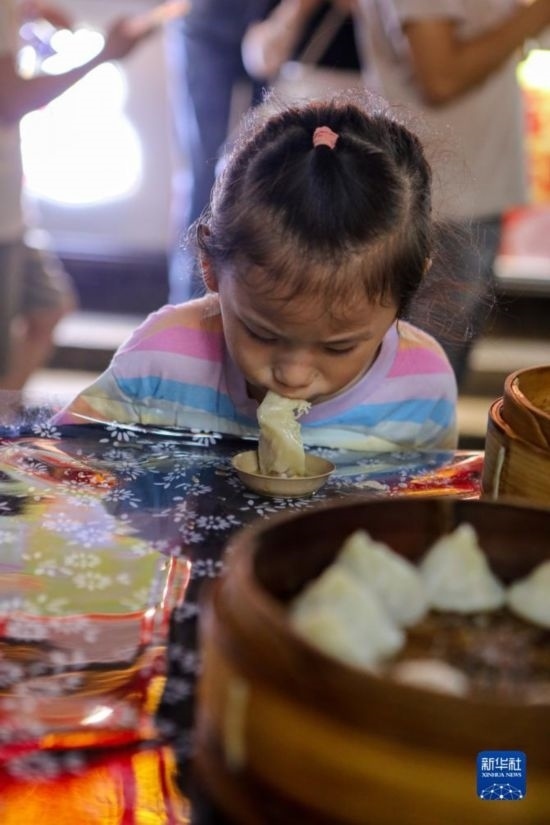 9月27日，小朋友在南翔小籠長街宴上品嘗南翔小籠。