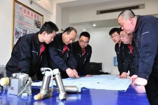 △李志強(qiáng)（左二）與班組成員在研究工作。