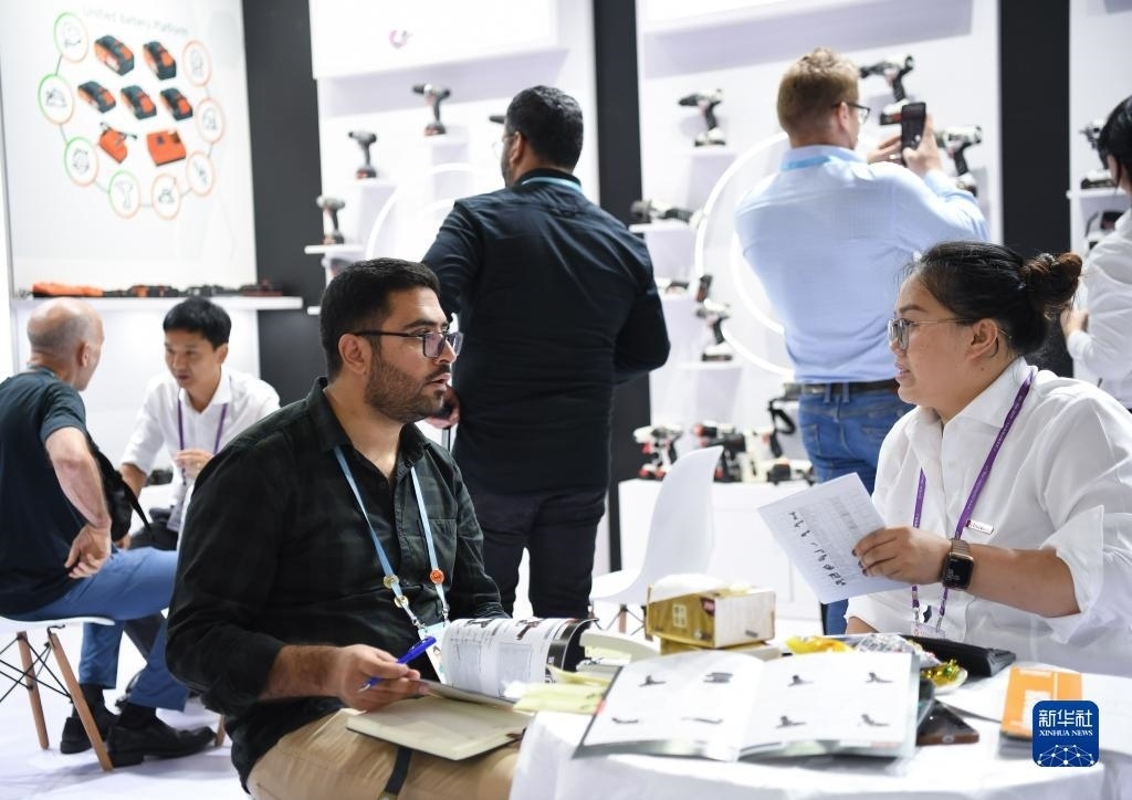 10月15日，在一家電動(dòng)工具展臺(tái)，外國采購商在洽談業(yè)務(wù)。新華社記者 鄧華 攝