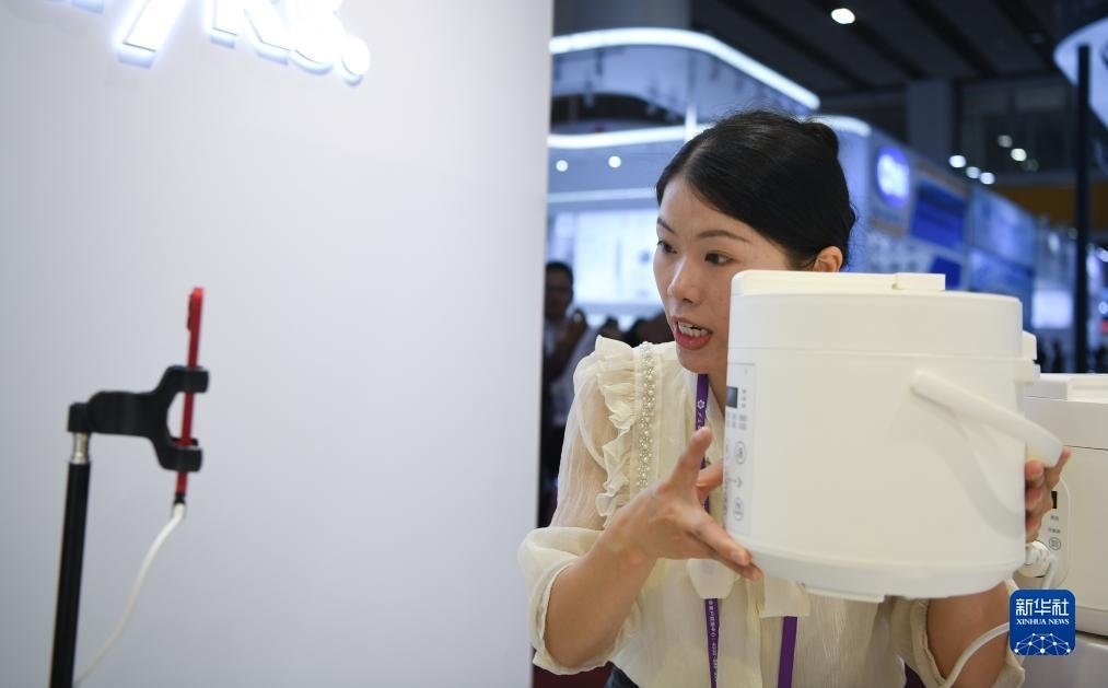 10月15日，參展的工作人員在展臺(tái)直播介紹家電產(chǎn)品。新華社記者 鄧華 攝