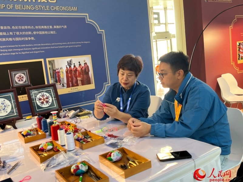 記者在新聞中心非遺傳承人展區(qū)進(jìn)行體驗(yàn)。人民網(wǎng)記者 杜燕飛攝