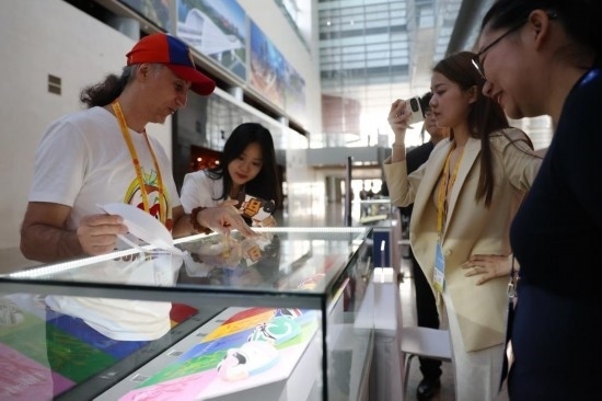 10月16日，參會(huì)記者在“一帶一路”國際合作高峰論壇新聞中心參觀展示的中國非物質(zhì)文化遺產(chǎn)展品。新華社記者 陳斌 攝