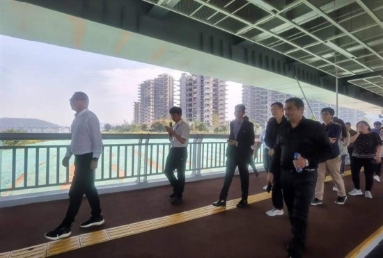 10月24日，2023“一帶一路”媒體合作論壇聯(lián)合采訪團(tuán)團(tuán)員走在清水塘大橋景觀通道上。本報(bào)記者 常雯宜攝