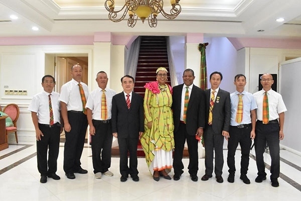 多米尼克總統(tǒng)伯頓和駐多米尼克大使林先江與中國農業(yè)技術專家組合影。中國駐多米尼克大使館供圖