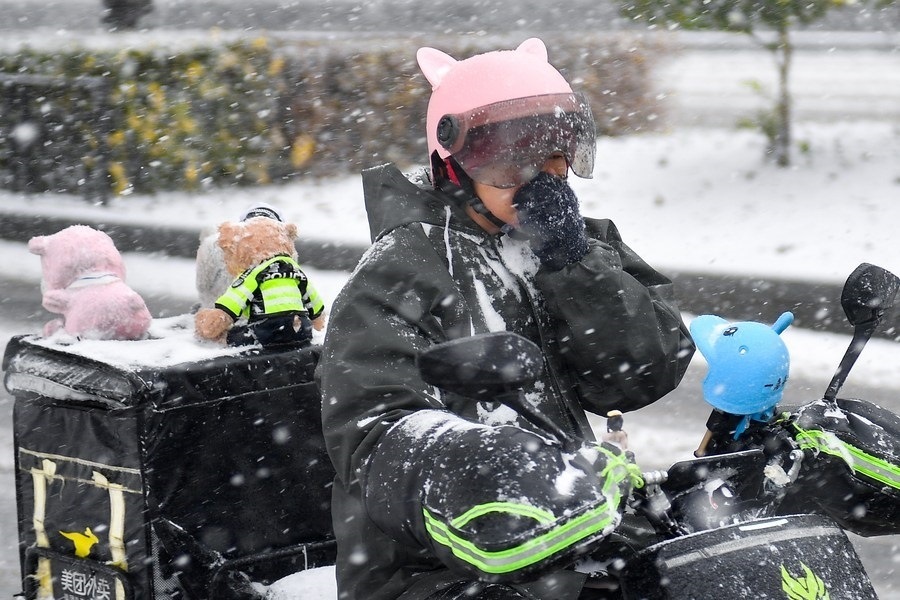 11月6日，在長春市街頭，一名外賣員在雪中騎行。新華社記者 許暢 攝