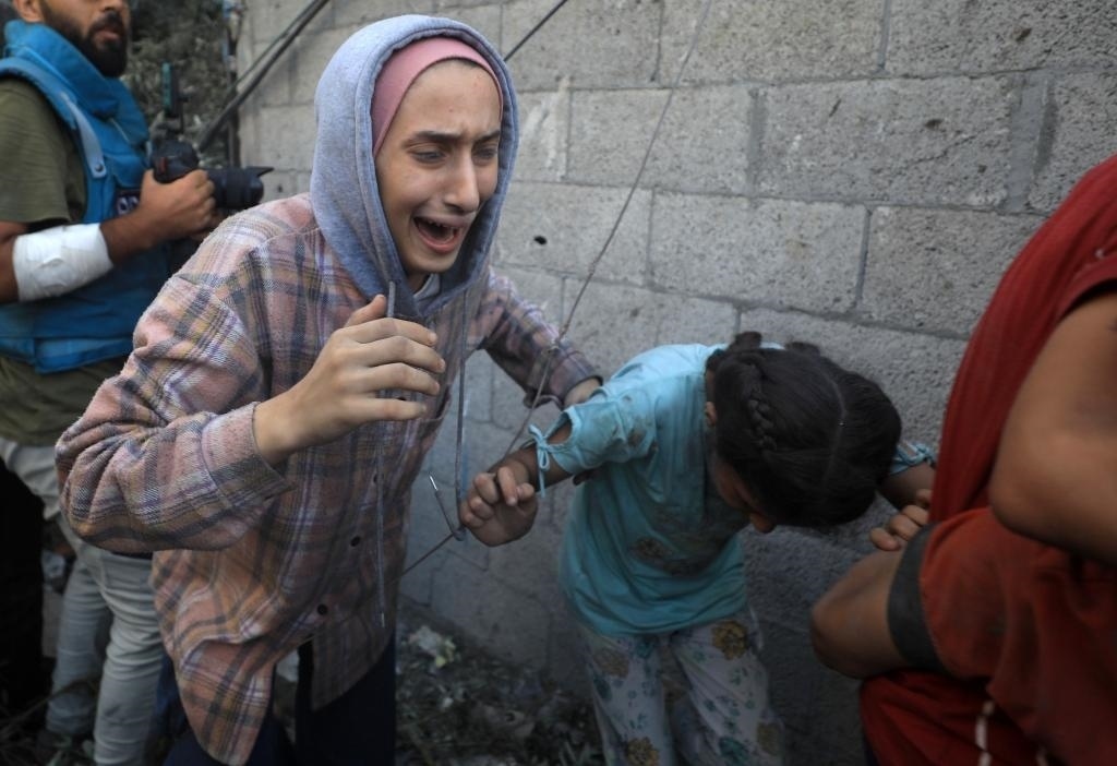 11月6日，人們從加沙地帶中部地區(qū)一處被炸難民營逃離。新華社發(fā)（亞西爾·庫迪攝）