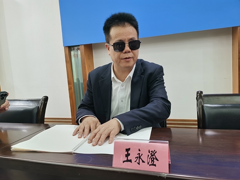 全國人大代表王永澄正在閱讀盲文版代表建議答復。本報記者 張 璁攝