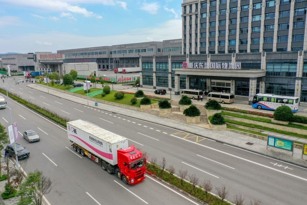 2023年10月11日，滿載筆記本電腦配件、發(fā)電機(jī)組件等產(chǎn)品的西部陸海新通道跨境公路班車從重慶南彭公路保稅物流中心駛出，將途經(jīng)廣西憑祥，直達(dá)越南（無人機(jī)照片）。新華社記者 黃偉 攝