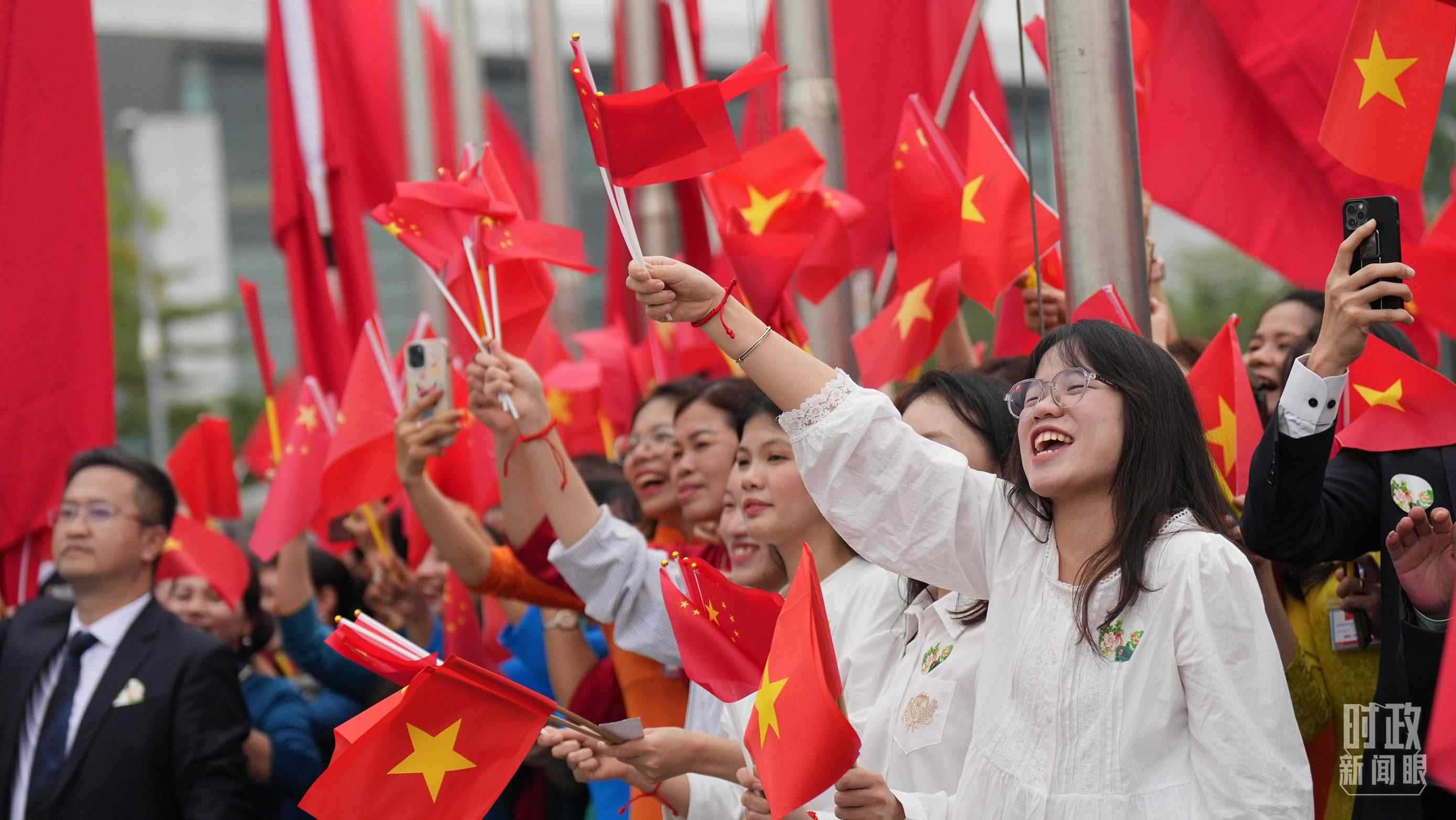 △人們揮舞兩國(guó)旗幟歡迎習(xí)近平訪(fǎng)越。（總臺(tái)國(guó)廣記者李晉拍攝）