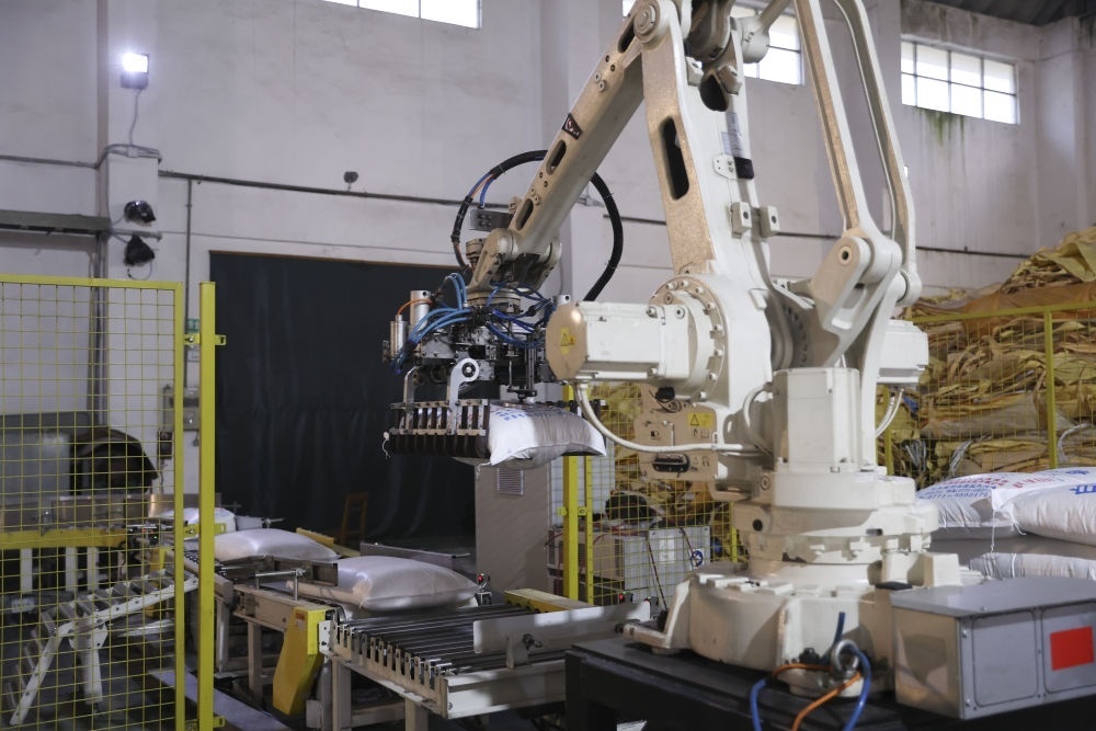 12月14日，在廣西來(lái)賓東糖鳳凰有限公司，機(jī)械臂在廠房碼放白砂糖成品。