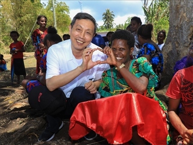 2023年12月18日，中國駐瓦努阿圖大使李名剛和前來觀看瓦努阿圖公路項目二期馬勒庫拉段移交儀式的當(dāng)?shù)鼐用窈嫌?。人民網(wǎng) 賀吉攝