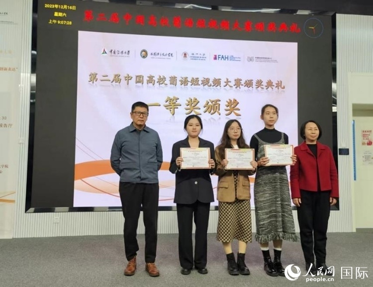 澳門大學中葡雙語教學暨培訓中心主任姚京明（左一）和中國傳媒大學外國語言文化學院院長文春英（右一）為一等獎獲得者頒獎。人民網記者 魯揚攝