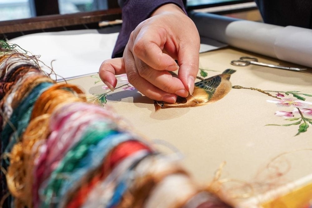 △2023年7月6日，盧建英在江蘇蘇州平江路的工作室內(nèi)刺繡。