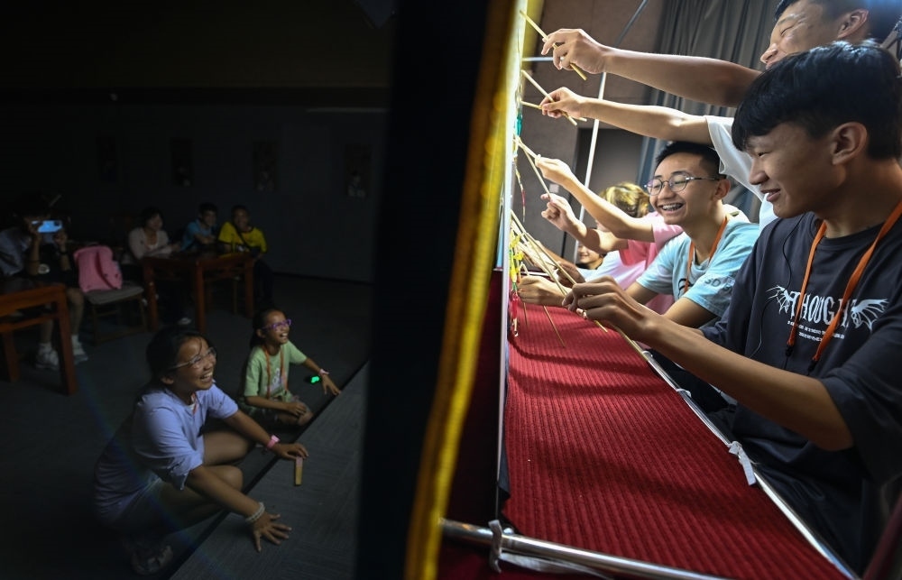 2023年8月8日，進行暑期研學的學生在位于陜西省西安市的中國秦腔藝術(shù)博物館體驗皮影戲演出。新華社記者 鄒競一 攝