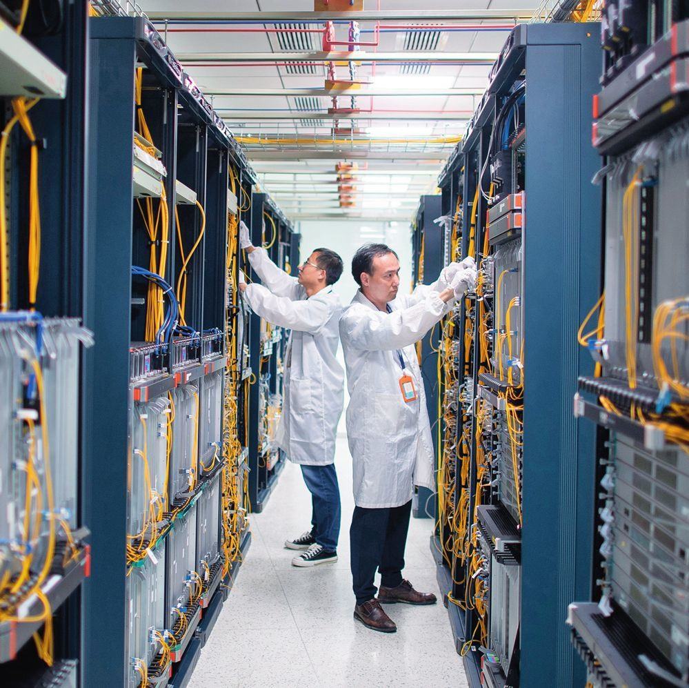 在位于武漢中國光谷的光電器件研發(fā)制造商——武漢光迅科技股份有限公司生產(chǎn)車間內(nèi)，技術(shù)人員在光模塊生產(chǎn)線作業(yè)（2023年4月11日攝）。程敏攝/本刊