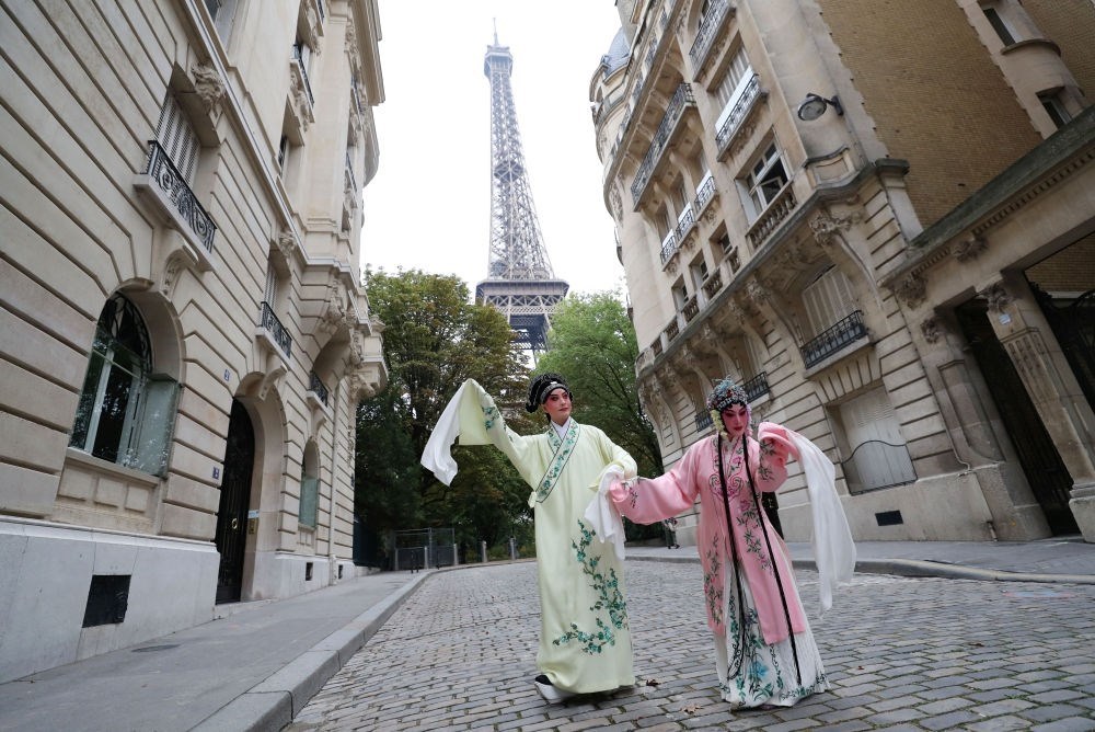 2023年9月13日，江蘇省演藝集團(tuán)昆劇院院長(zhǎng)施夏明（左）和江蘇省演藝集團(tuán)昆劇院國(guó)家一級(jí)演員孔愛(ài)萍在法國(guó)巴黎埃菲爾鐵塔附近參加昆曲快閃。新華社記者 高靜 攝