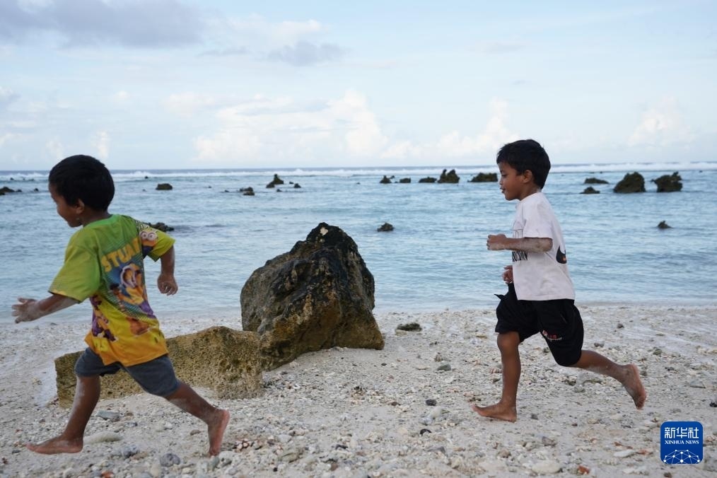 1月20日，兒童在瑙魯海邊嬉戲。新華社記者 王申 攝