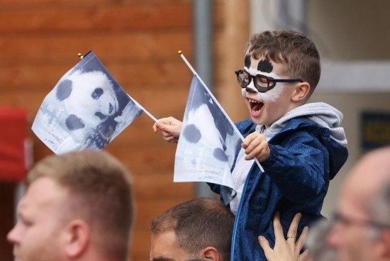  2023年7月26日，在法國(guó)圣艾尼昂市博瓦勒野生動(dòng)物園外，一名兒童等待送別熊貓“圓夢(mèng)”。新華社記者 高靜 攝