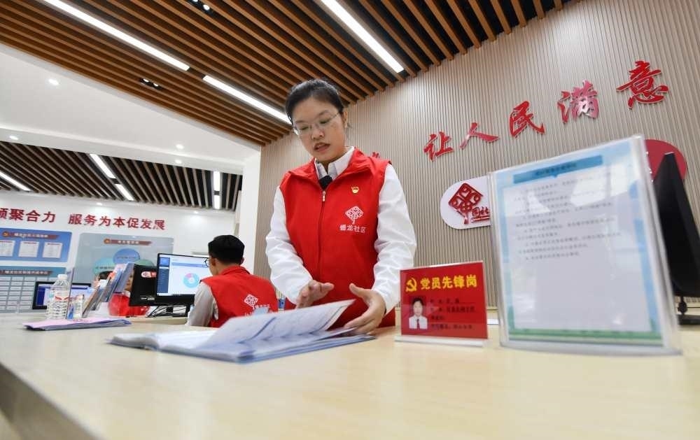 △2023年12月14日，廣西南寧市蟠龍社區(qū)，工作人員在為居民服務(wù)。