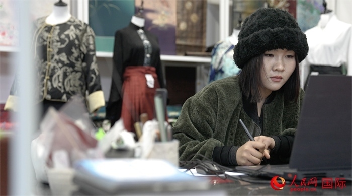 1月23日，在山東省菏澤市曹縣有愛云倉直播基地，張子晨正在設(shè)計漢服。 人民網(wǎng)記者 袁蒙攝