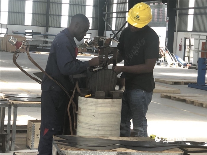 經(jīng)貿(mào)合作區(qū)廠房內(nèi)，當?shù)毓と苏诰o張作業(yè)。人民網(wǎng)記者 黃培昭攝