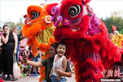 圖為舞獅表演吸引民眾合影。張興龍攝