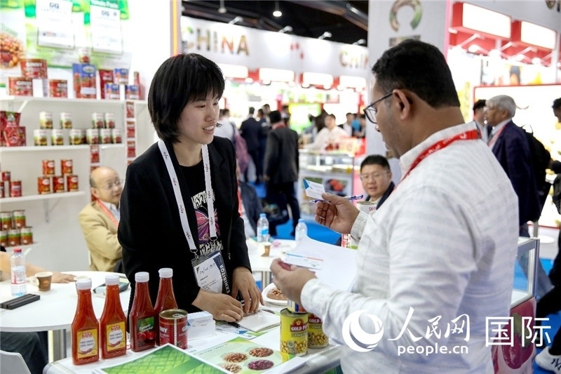 圖為中國參展企業(yè)代表與采購商交流。人民網(wǎng) 塔里克·易卜拉欣攝