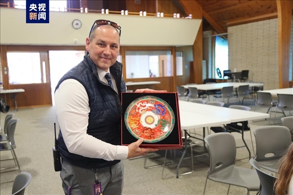 △馬斯卡廷中學(xué)高中部校長瑞安·卡斯爾代表學(xué)校接受總臺文創(chuàng)產(chǎn)品