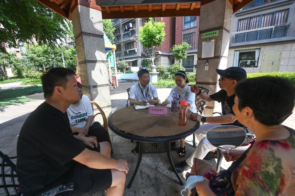 △2023年7月21日，在位于浙江杭州臨安區(qū)錦南街道水岸陽光小區(qū)的陽光議事廳，街道干部在聽取居民們反映的問題及意見。