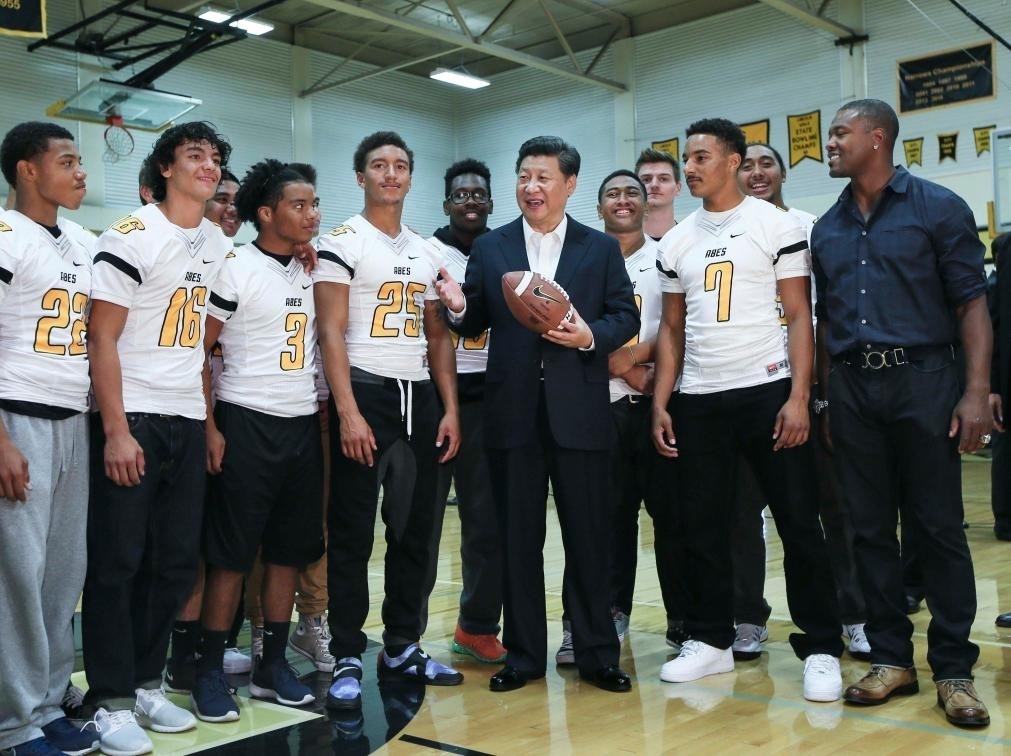 2015年9月23日，國(guó)家主席習(xí)近平參觀美國(guó)塔科馬市林肯中學(xué)。這是習(xí)近平在學(xué)校體育館，同上橄欖球訓(xùn)練課的學(xué)生們親切交談。新華社記者 蘭紅光 攝